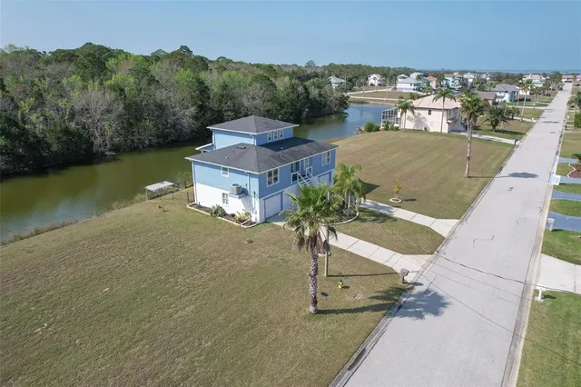 a view of a house with a yard and lake view