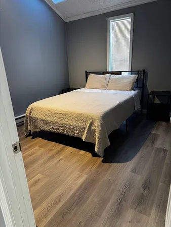 a bed sitting in a bedroom next to a window