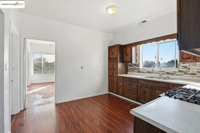 a kitchen with stainless steel appliances granite countertop a stove a sink and a refrigerator