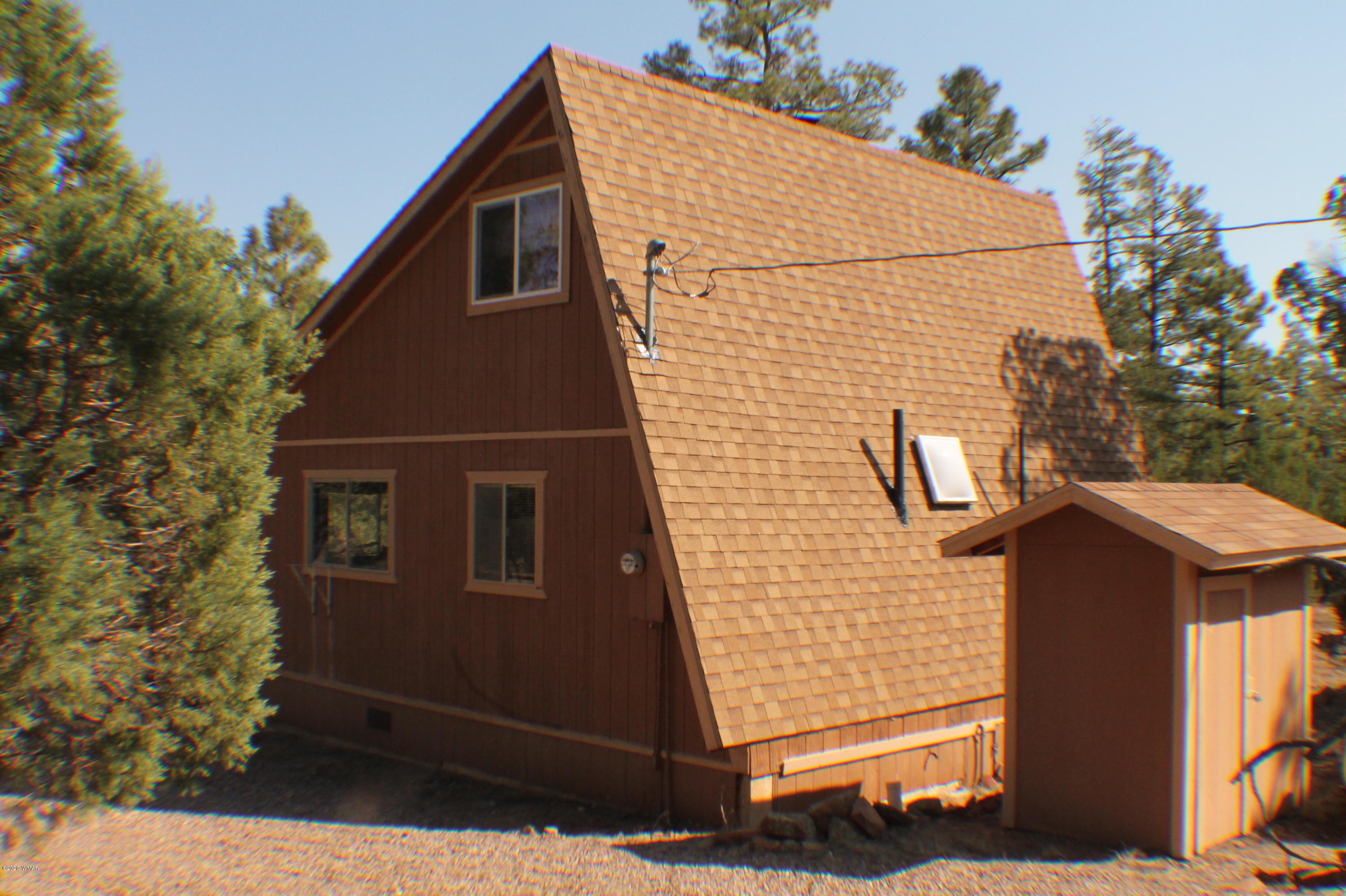 2048 Gilbert Lane Overgaard, AZ 85933 - Photo 9 of 41 a brick house with a small yard and plants