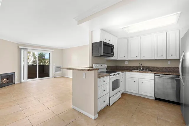 a kitchen with granite countertop cabinets stainless steel appliances and a counter space