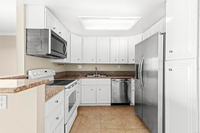 a kitchen with stainless steel appliances granite countertop a refrigerator and a stove top oven