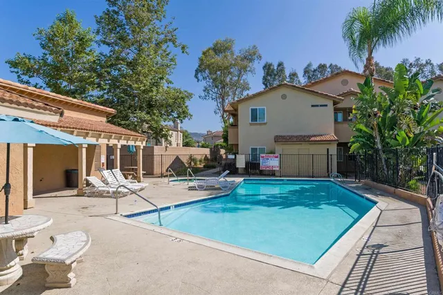 a view of a patio with table and chairs potted plants and palm tree