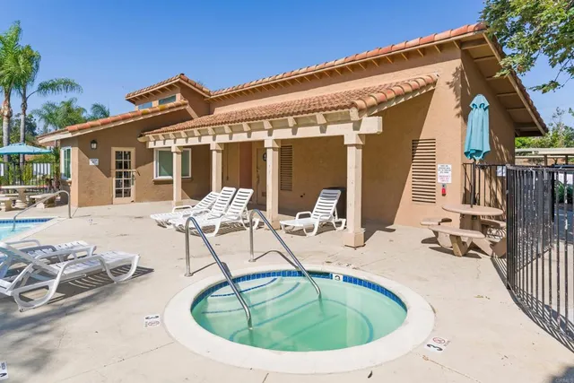 a view of a house with backyard sitting area and swimming pool