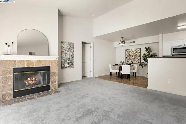 a living room with furniture and a dining table with kitchen view
