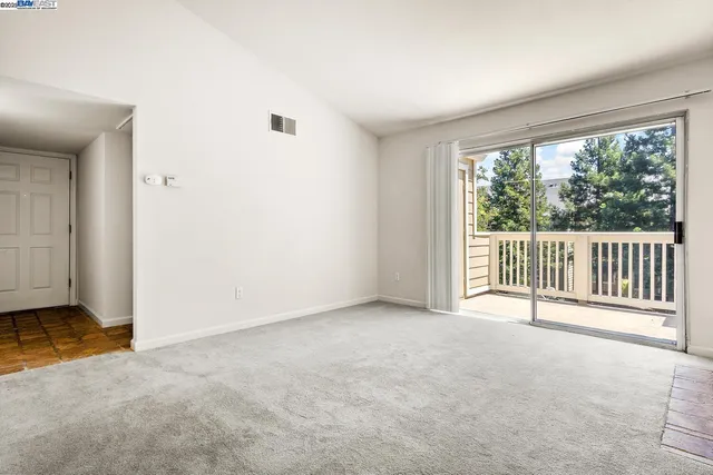 an empty room with fireplace and windows