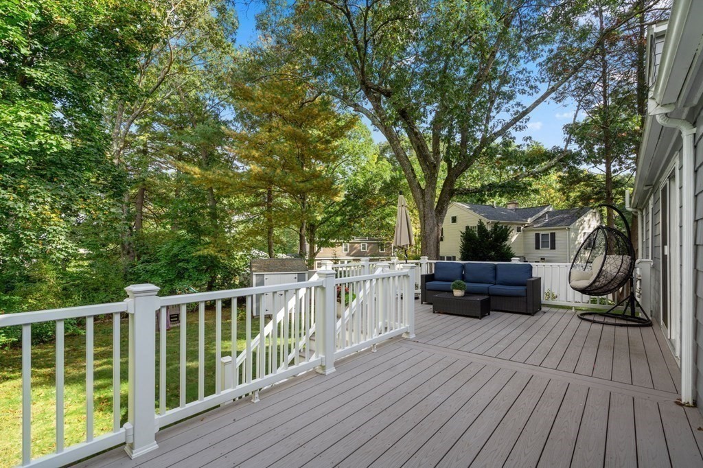 119 Sylvan Road Needham, MA 02492 - Photo 18 of 23 a view of house with deck outdoor seating and trees in the background