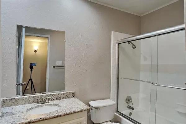a bathroom with a granite countertop sink toilet and shower