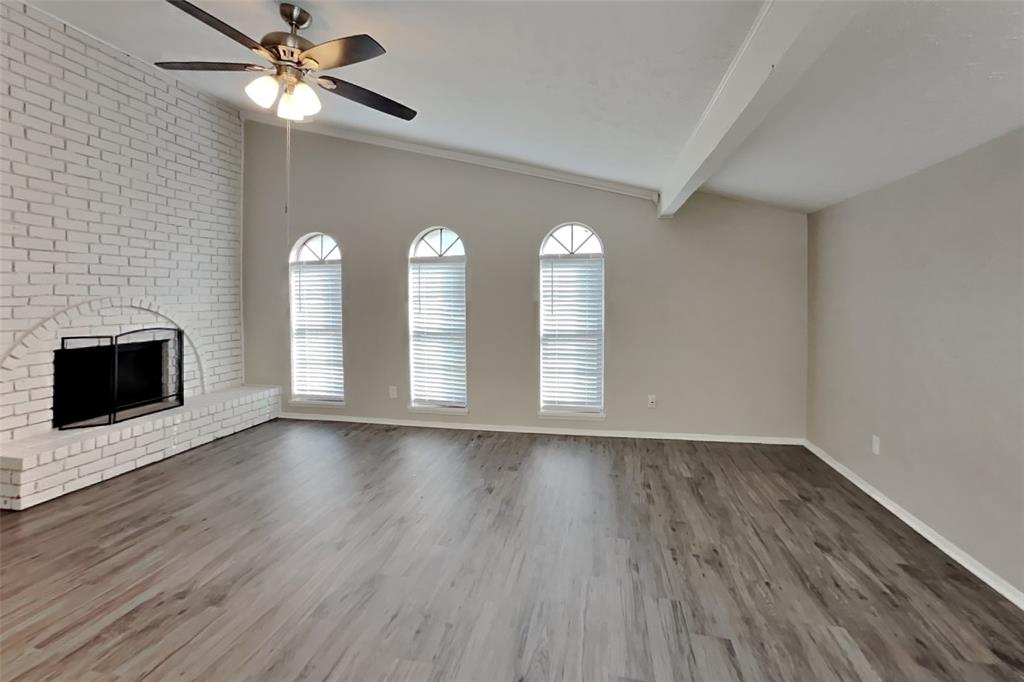 2709 Roman Way Garland, TX 75040 - Photo 4 of 16 an empty room with wooden floor fan and windows