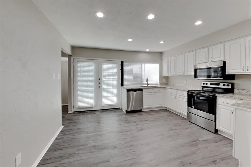 2709 Roman Way Garland, TX 75040 - Photo 5 of 16 a kitchen with granite countertop white cabinets and stainless steel appliances