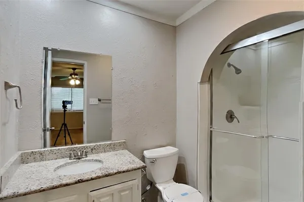 a bathroom with a granite countertop sink toilet and shower