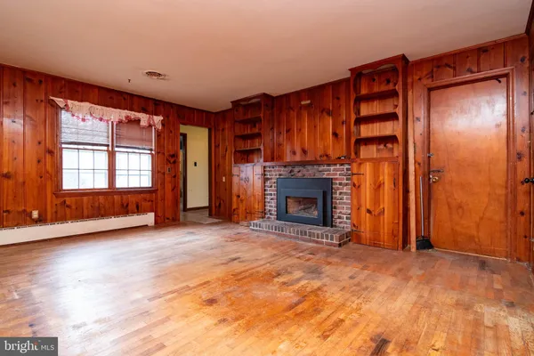 a view of an empty room with a fireplace and a window