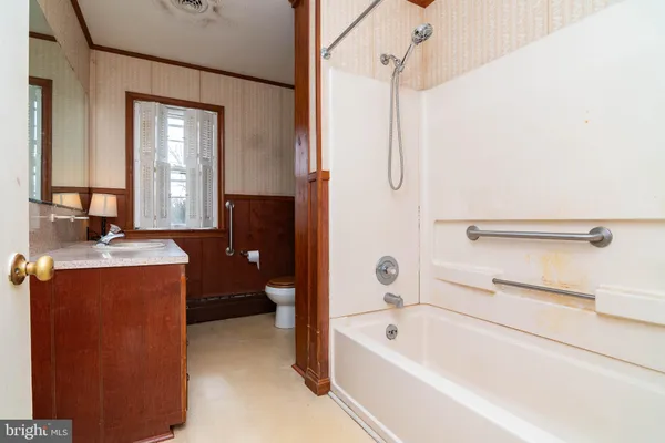 a bathroom with a tub sink and mirror