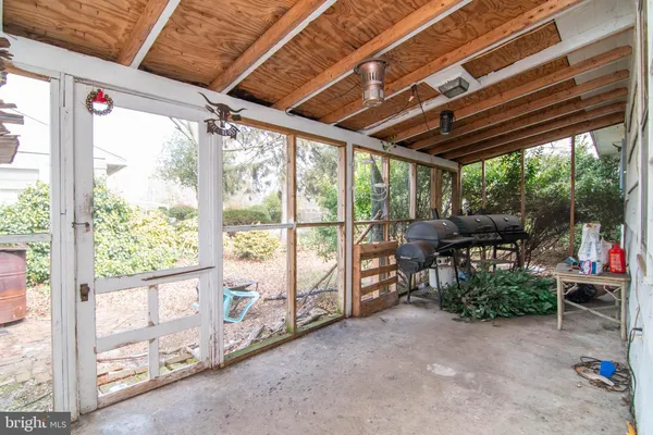 a view of a porch with chairs and floor to ceiling window