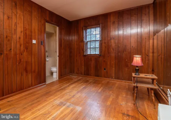 a view of an empty room with windows and wooden floor