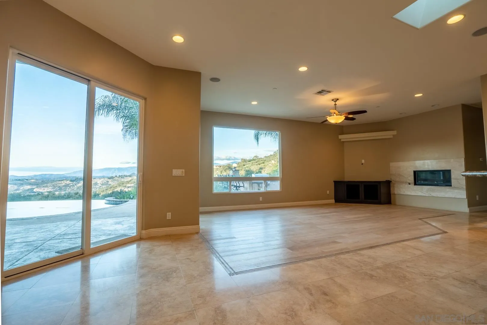 14184 Ridge Canyon Road Valley Center, CA 92082 - Photo 10 of 39 a view of an empty room with a fireplace and a window