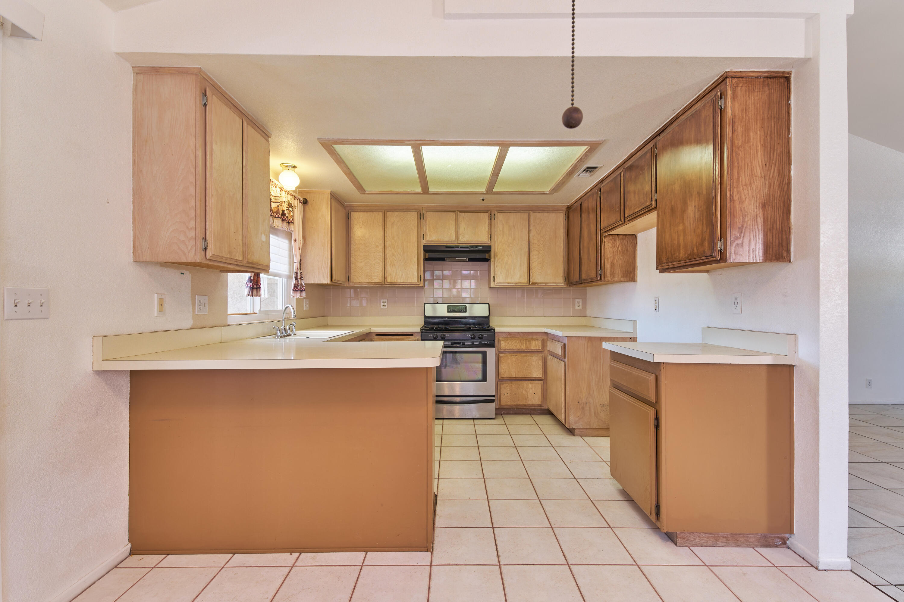 66097 San Jose Road Desert Hot Springs, CA 92240 - Photo 8 of 26 a kitchen with stainless steel appliances granite countertop a sink counter space cabinets and a large window