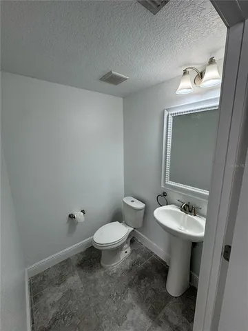 a bathroom with a sink toilet and mirror