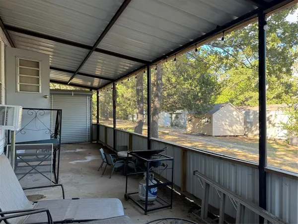 a view of a porch with furniture and a yard
