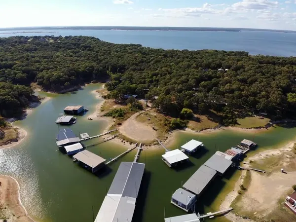 an aerial view of lake residential house with outdoor space and trees around