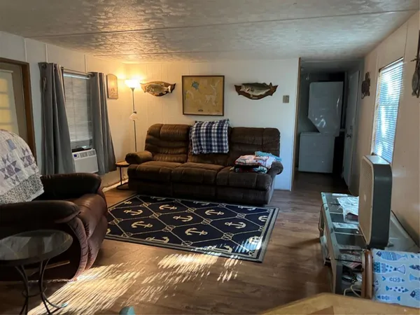 a living room with furniture and a refrigerator