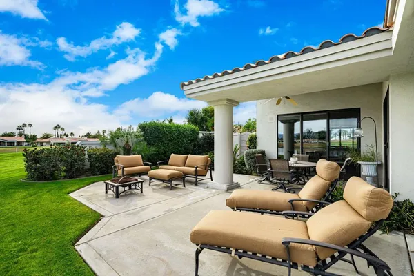 a view of a patio with couches and a table and chairs with garden view