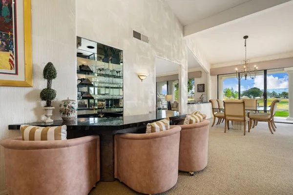 a living room with couches and kitchen view with wooden floor