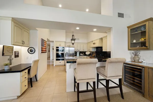 a kitchen with stainless steel appliances kitchen island granite countertop a stove a sink a dining table and chairs