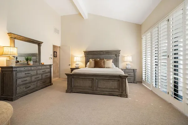 a spacious bedroom with a bed and a cabinets