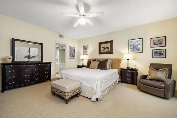 a spacious bedroom with a bed a couch and a dresser