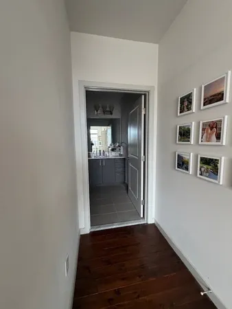 a view of a hallway with wooden floor and a living room