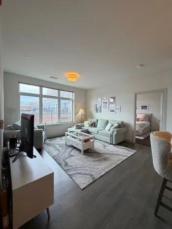 a living room with furniture large window and a table