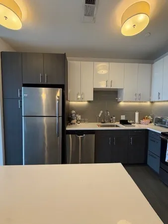 a kitchen with granite countertop a refrigerator and a stove top oven