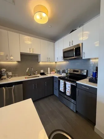 a kitchen with stainless steel appliances granite countertop a stove a sink a refrigerator and a microwave