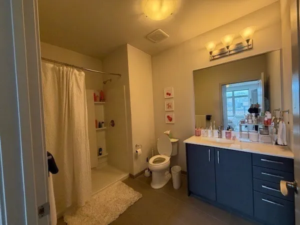 a bathroom with a double vanity sink mirror and toilet