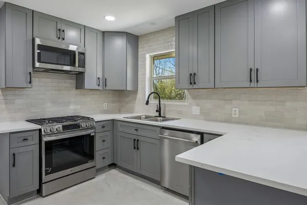 a kitchen with a sink stove and microwave