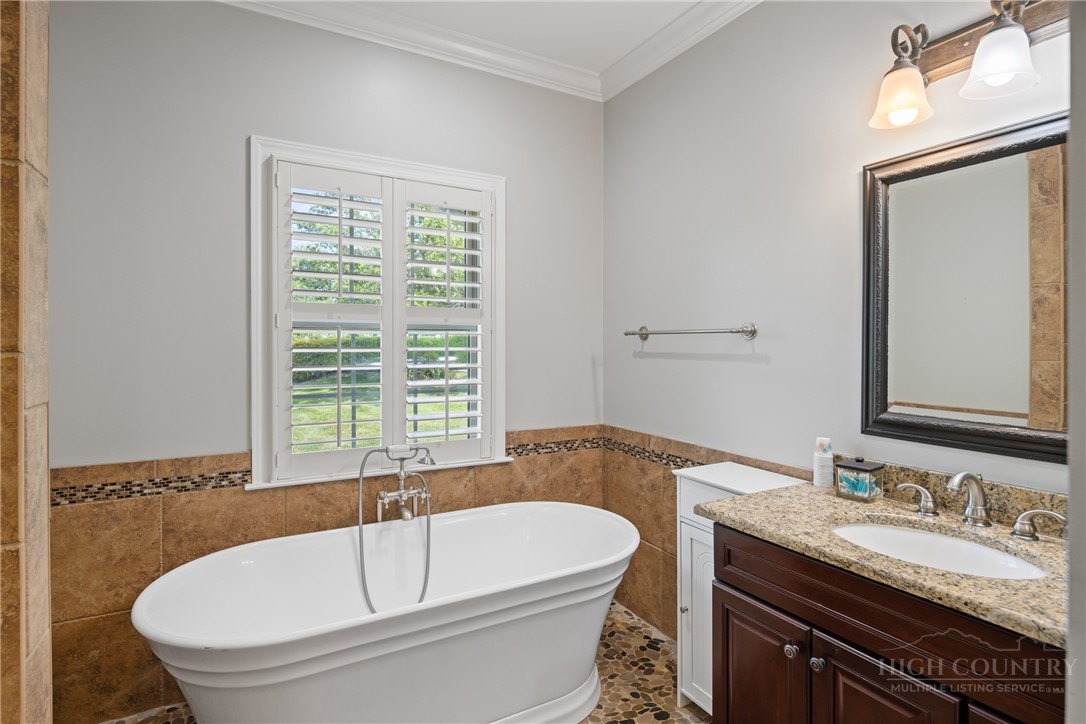 147 Riverside Park Court, Unit G2 Jefferson, NC 28640 - Photo 12 of 44 a bathroom with a granite countertop sink and a bathtub