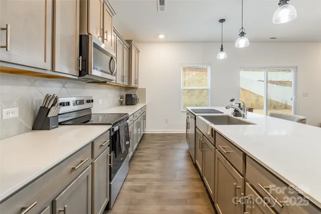 a kitchen with stainless steel appliances a sink stove and cabinets