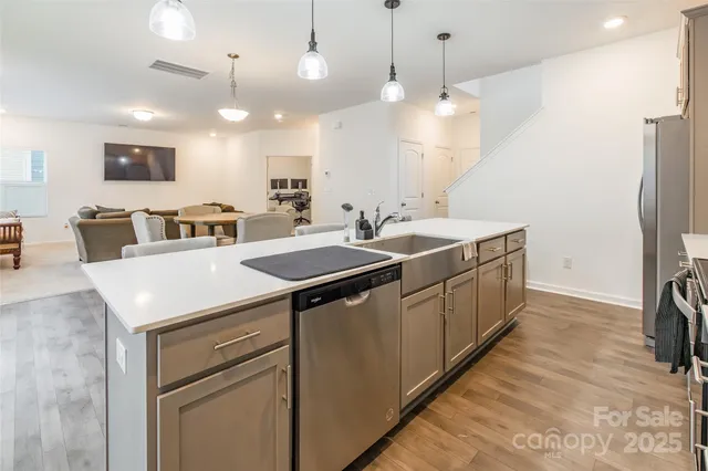 a kitchen that has a lot of white cabinets and stainless steel appliances