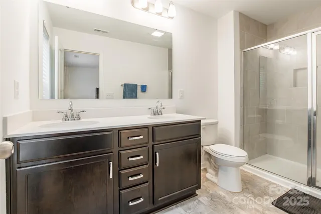 a bathroom with a sink toilet a mirror and shower