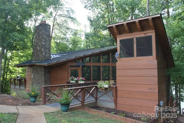 a view of house with outdoor seating and trees