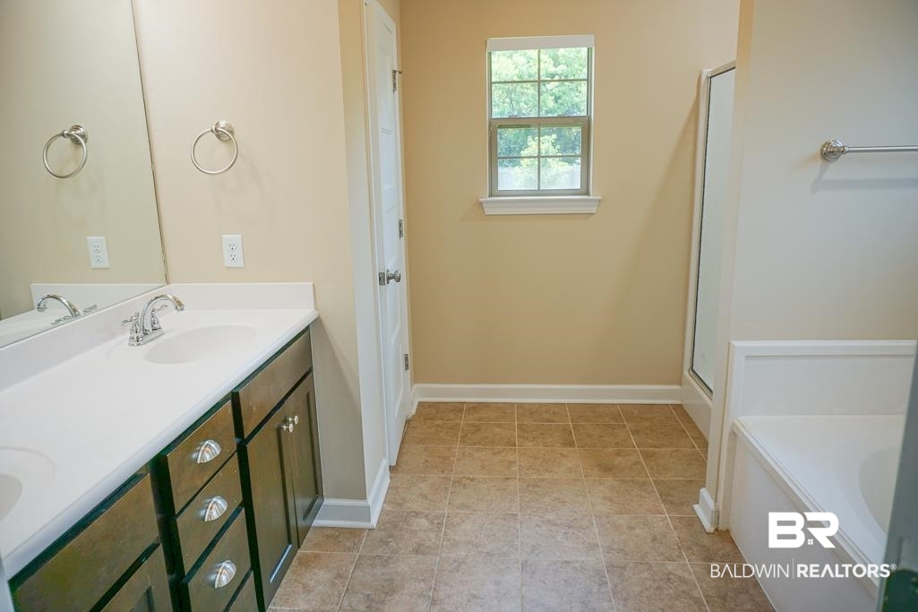 593 Begeman Road Mobile, AL 36608 - Photo 14 of 23 Bathroom featuring dual bowl vanity, a bath, and tile floors