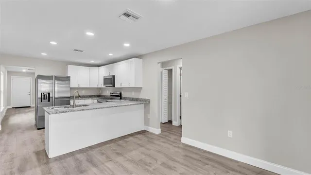 a kitchen with stainless steel appliances granite countertop a sink and a refrigerator