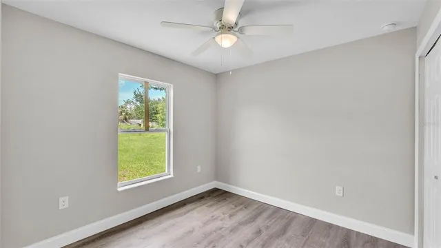 an empty room with a window and a fan
