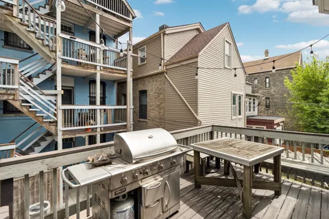 a view of a rooftop deck with couch and chairs