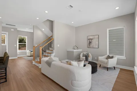 a living room with furniture and a wooden floor