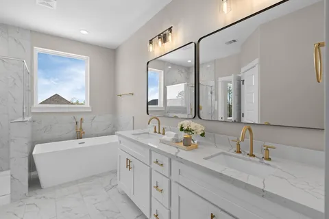 a bathroom with a double vanity sink mirror and bathtub