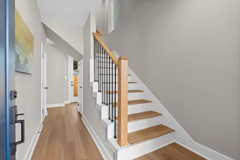 a view of a hallway with wooden floor and staircase