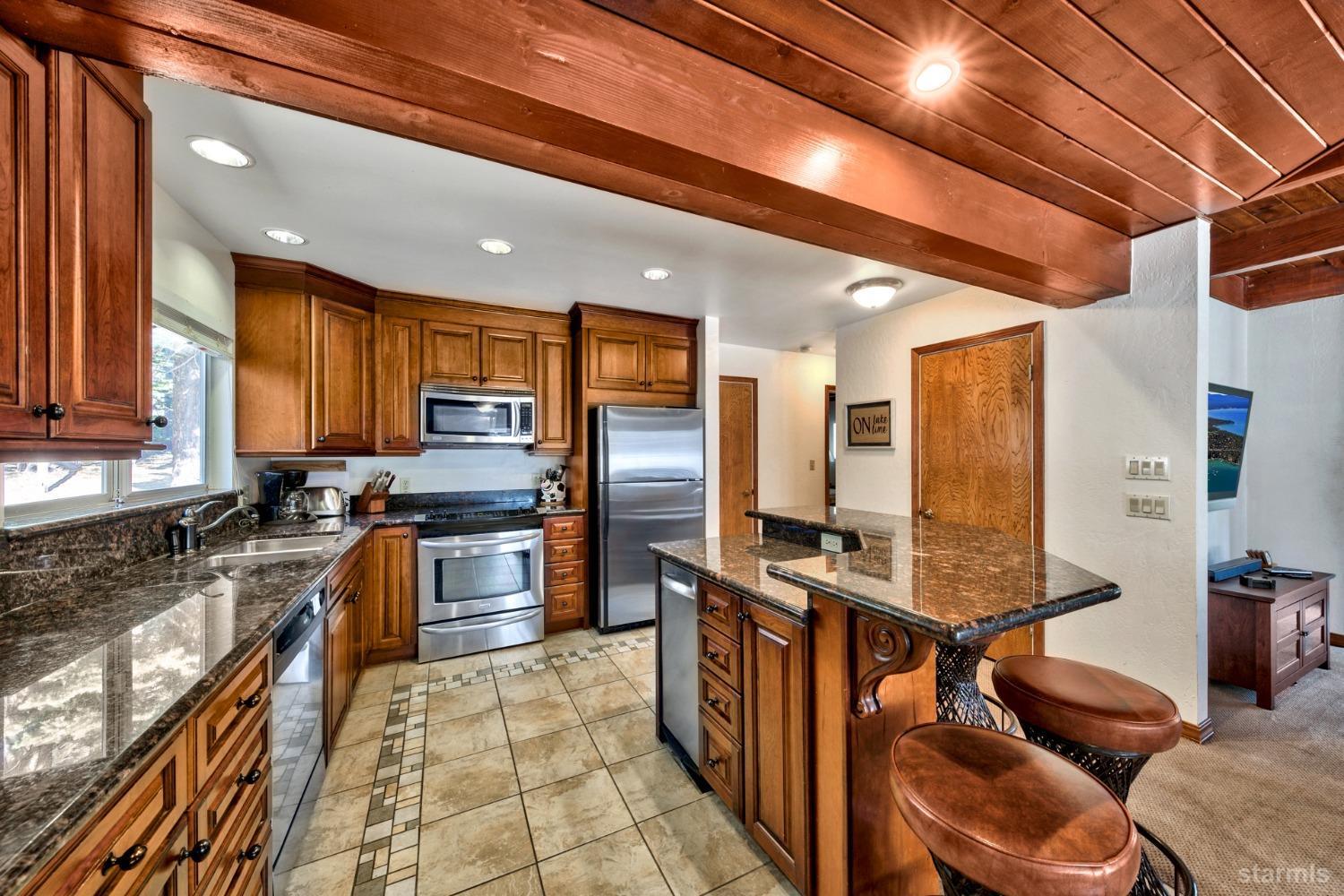 2004 Kickapoo Street South Lake Tahoe, CA 96150 - Photo 7 of 20 a large kitchen with stainless steel appliances granite countertop a sink refrigerator and cabinets