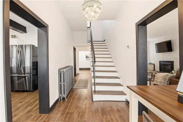 a view of a hallway with wooden floor and staircase